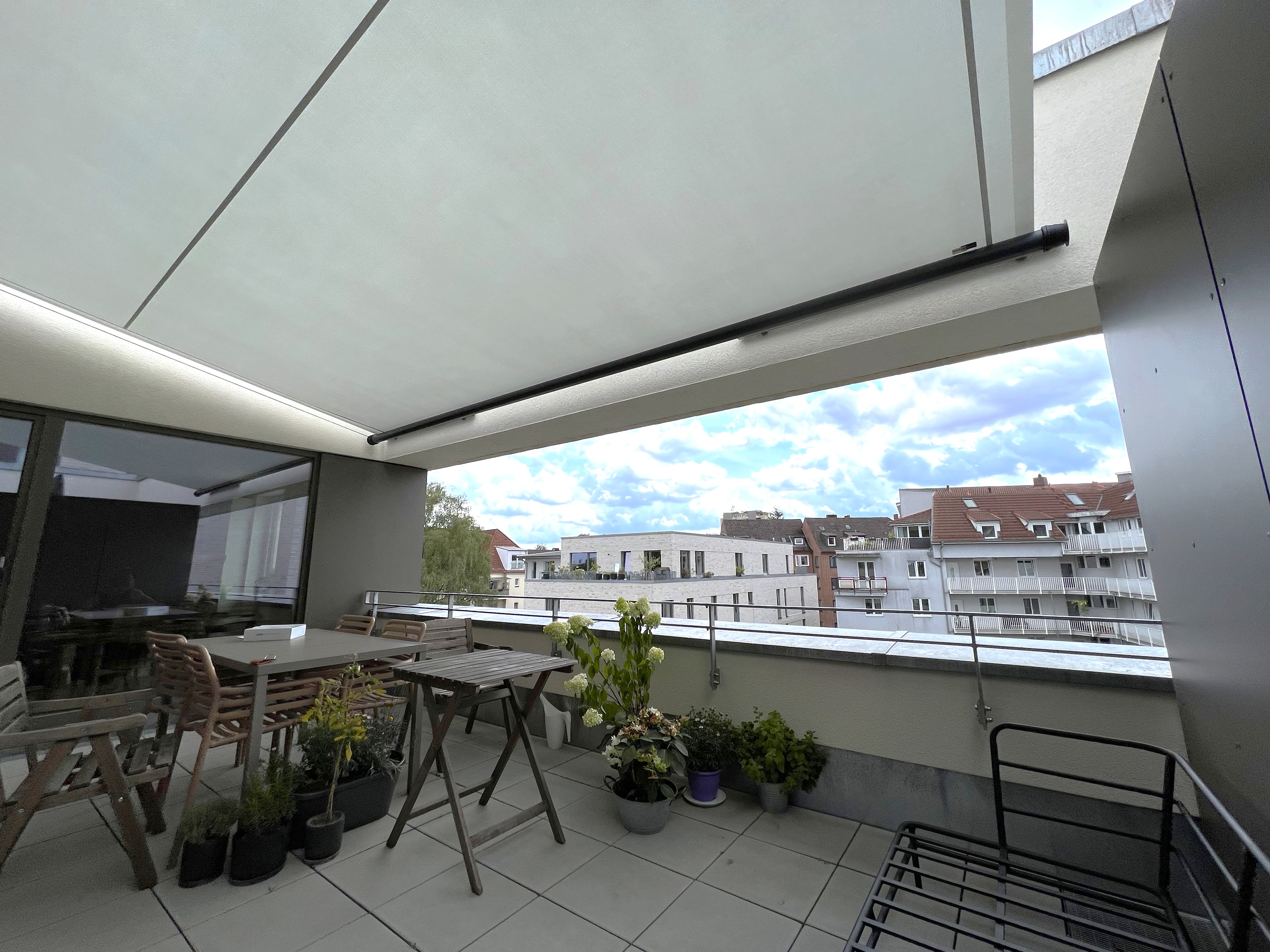 zurückhaltende Verankerung am Mauerwerk des Sonnensegels Structures auf dem Dachbalkon