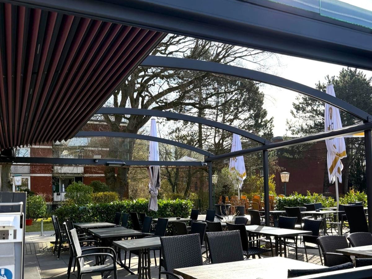 Restaurant Il Tesoro mit Blick auf die gastronomische Außenfläche mit Tischgruppen, überspannt von einer halbgeöffneten Pergola Crown von Zschimmer Sonnenschutz, Gastro-Überdachung Hamburgaus Hamburg