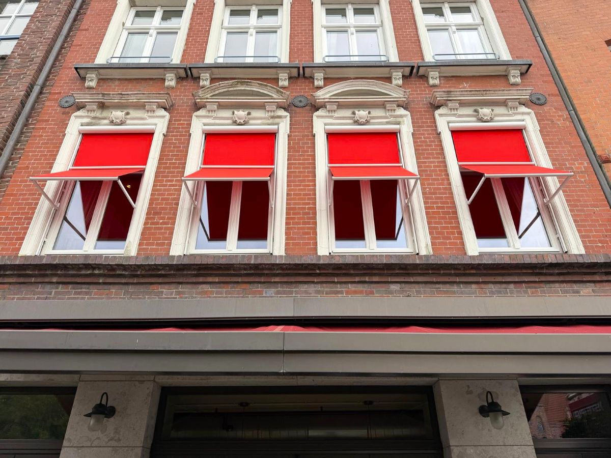 Rote Fallarmmarkisen in Markisoletten-Ausführung vor den Fenstern am Blockhouse in Lübeck