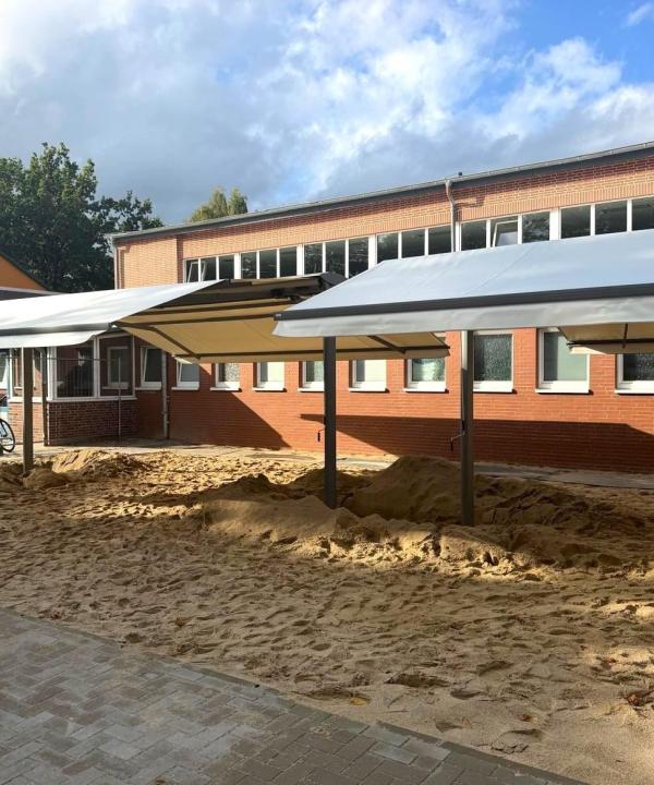 Markisen überspannen eine große Sandkasten einer Schule in Hamburg, Projekt Zschimmer