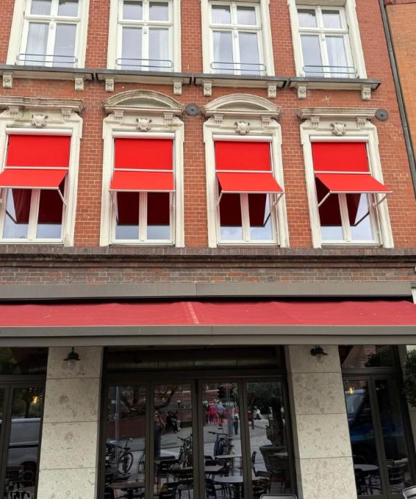 Fenstermarkisen in rot als Markisoletten-Lösung am Block House in Lübeck