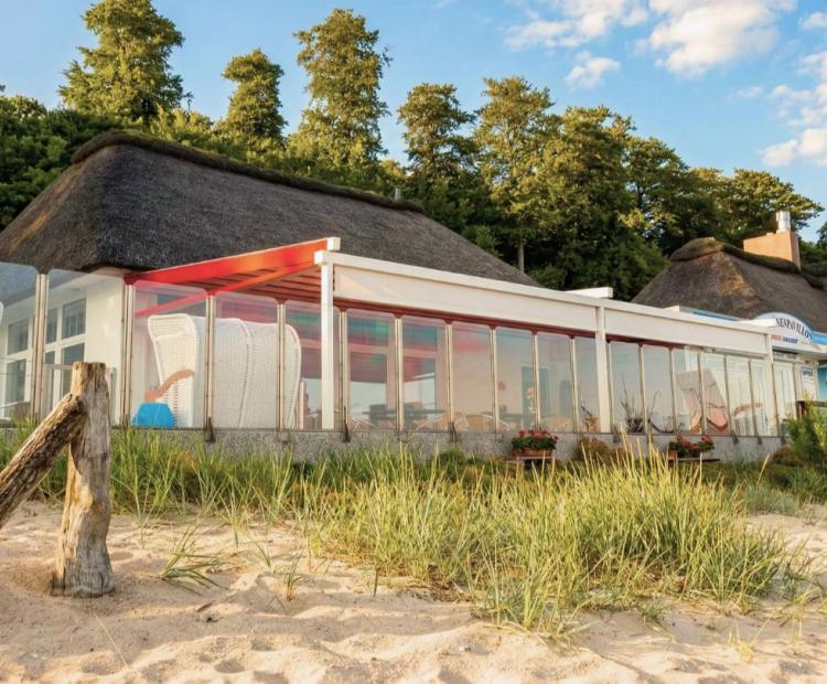 Rotes Pergoladach überspannt eine Außengastronomie an der Küste in Scharbeutz - Zschimmer Projekt