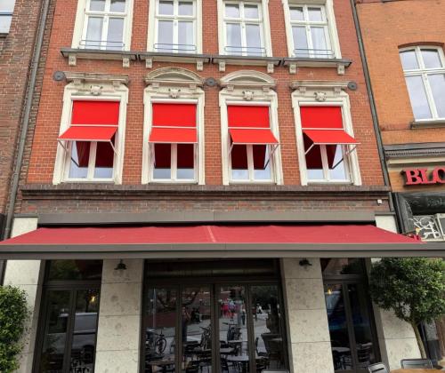 Fenstermarkisen in rot als Markisoletten-Lösung am Block House in Lübeck