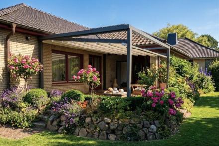 Ausgefahrene, weiße Pergola Markise Sunrain Q mit abgesenkten Markisentuch überspannt die Terrasse eines Einfamilienhaus