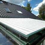 geschlossene Oberglasmarkise oberhalb eine großen Glasdachs für besseren HItzeschutz im Wintergarten